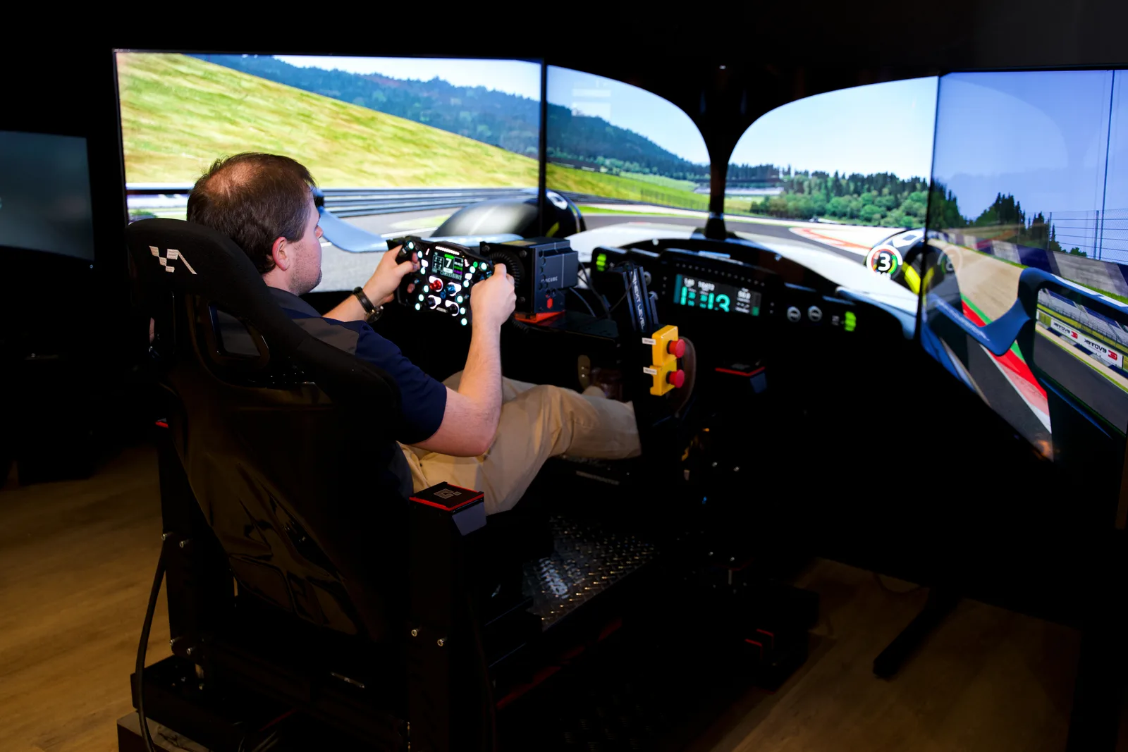 Driver in the triple-screen racing simulator at 19th Hole Indoor Golf & Social