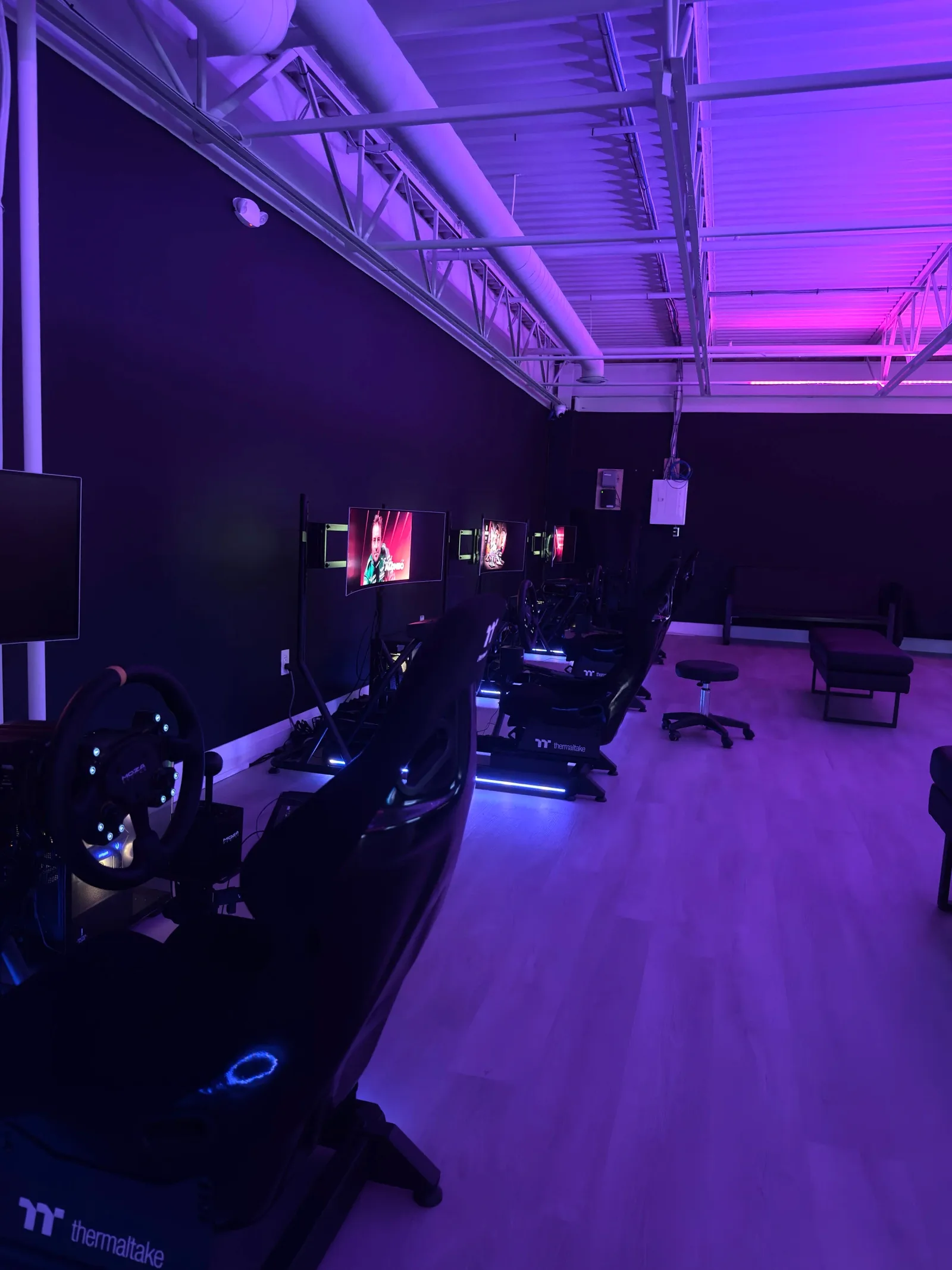 Purple-lit simulator room at First Last Sim Lounge