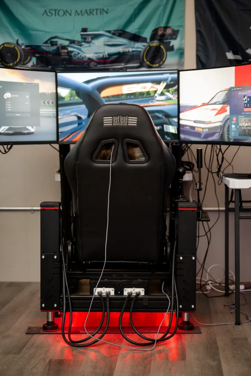Rear view of a DriVR motion racing cockpit and triple monitors.
